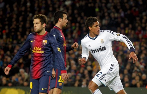 Real Madrid's Varane celebrates his goal past Barcelona's Alba and Busquets during their Spanish King's Cup semifinal second round soccer match in Barcelona