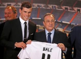 Gareth Bale of Wales hold his new Real Madrid soccer club jersey accompanied by president Florentino Perez at the Santiago Bernabeu stadium in Madrid,