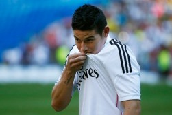 Colombia's soccer player James Rodriguez kisses his shirt during his presentation at the Santiago Bernabeu stadium in Madrid